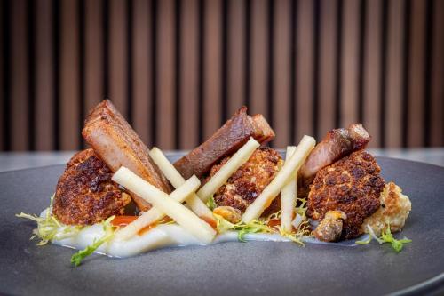 a plate of food with meat and french fries at Asperion Hillside Hotel in Guildford