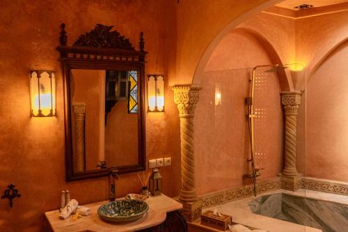 La salle de bains est pourvue d'un lavabo, d'un miroir et d'une baignoire. dans l'établissement Lalla Soulika, à Tanger
