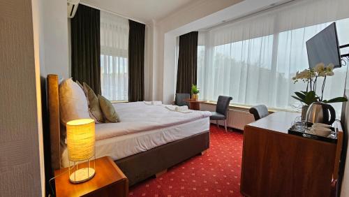 a hotel room with a bed and a desk with a lamp at Willa Furtak in Jawor