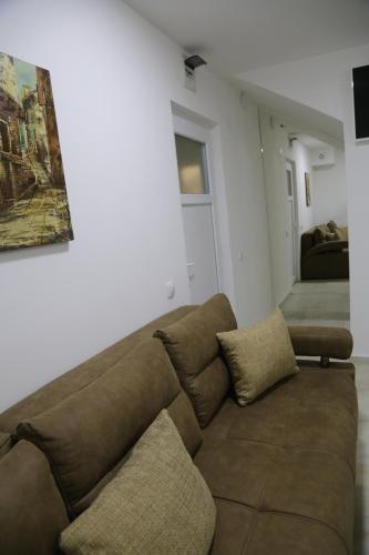 a living room with a brown couch in a room at Studio T&M, sa parkingom in Obrenovac