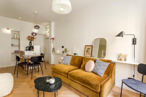 een woonkamer met een bank en een tafel bij Lune Montorgueil in Parijs