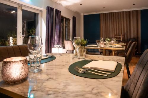 a dining room with a table with plates and wine glasses at Asperion Hillside Hotel in Guildford