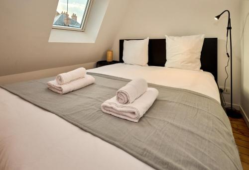 a bedroom with two towels on a bed at L'Atelier, atypique en hyper centre, situé dans un atelier d'architecte, by PRIMO C0NCIERGERIE in Nevers