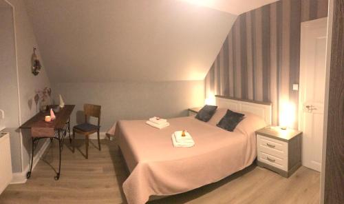 a bedroom with a bed with a table and a desk at Gîte Monts et Merveilles in Mollau