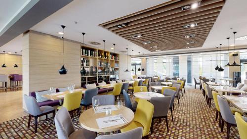 a restaurant with tables and chairs in a room at Premier Sofia Airport Hotel in Sofia