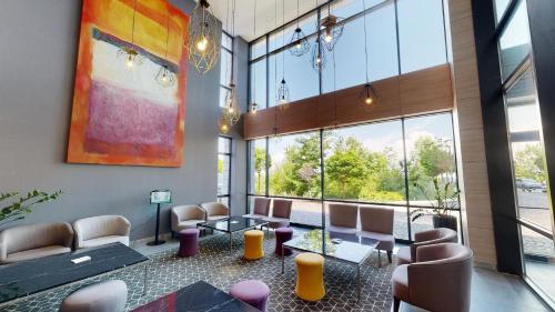 a waiting room with chairs and tables and large windows at Best Western Premier Sofia Airport Hotel in Sofia