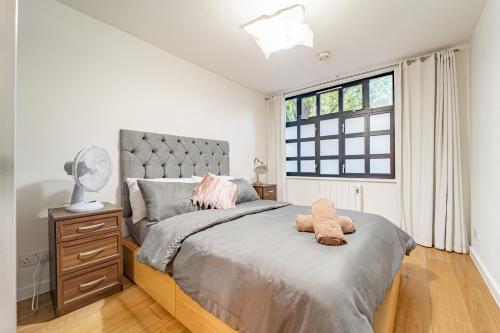 a bedroom with a large bed and a window at Modern flat in PRIME LOCATION near Shoreditch & Brick lane in London