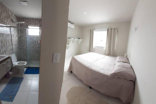 a small bedroom with a bed and a shower at Residencial Casa Grande- Apto 01 in Santa Cruz Cabrália