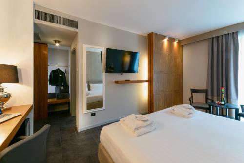 a hotel room with a bed and a desk and a tv at Admiral Park Hotel by Falco D'Oro Hotels in Zola Predosa
