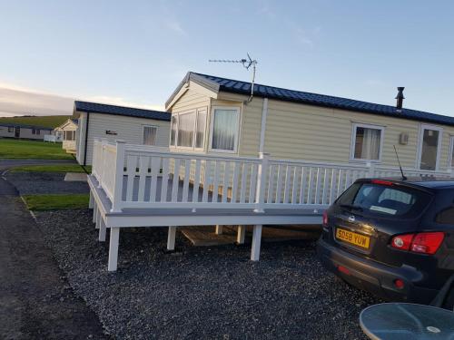 a car parked in front of a mobile home at 8 berth caravan Turnberry Holiday Park in Turnberry