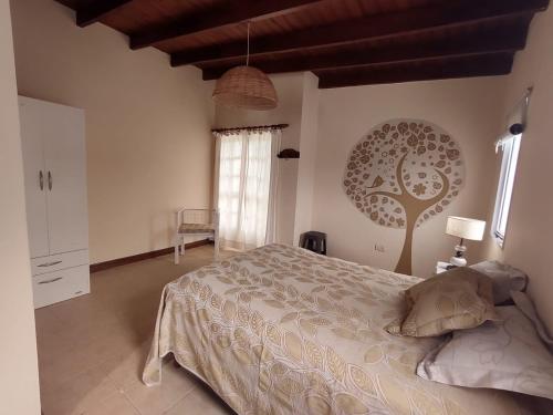a bedroom with a bed and a tree on the wall at DEPARTAMENTO UMARDA in Tandil