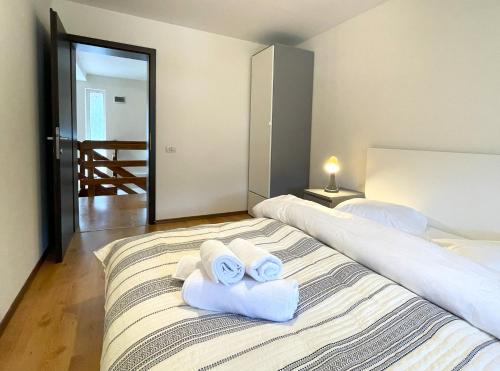 a bedroom with two white towels on a bed at Mountain Escape Loft in Buşteni