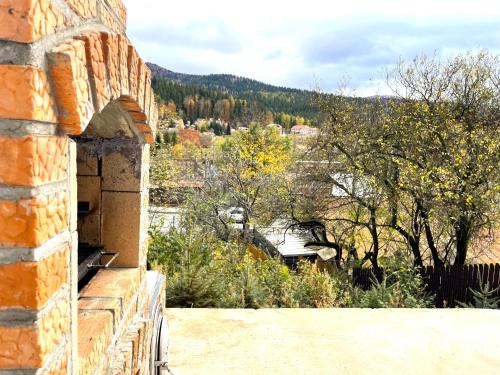 a view from the side of a brick building at Alpine Cottage w. Mountain View in Buşteni