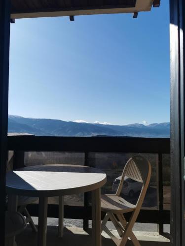 d'une table et de chaises sur un balcon avec vue sur les montagnes. dans l'établissement Chez les Copines Randonneuses, à Font-Romeu-Odeillo-Via