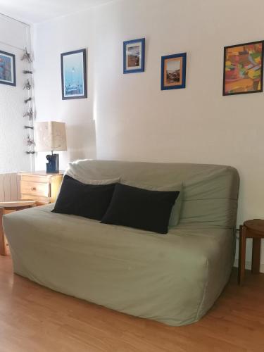 - un canapé dans le salon avec 2 oreillers dans l'établissement Chez les Copines Randonneuses, à Font-Romeu-Odeillo-Via