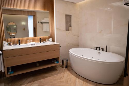 a bathroom with a large tub and a large mirror at Dana Beach Resort in Half Moon Bay