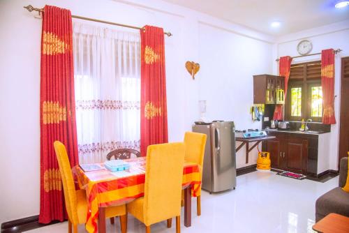 a kitchen with a table and chairs in a kitchen at City Beach Apartment in Bentota