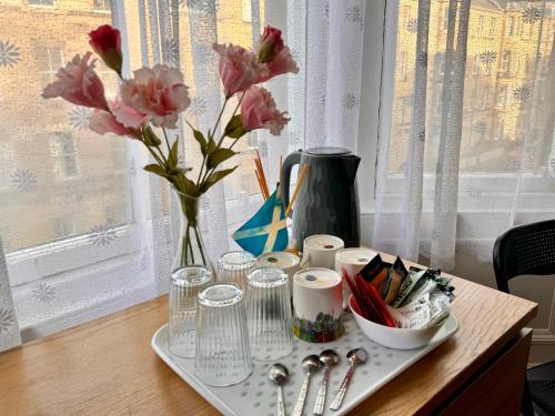 un plateau avec un vase de fleurs sur une table dans l'établissement Apart Bernard Rooms, à Édimbourg