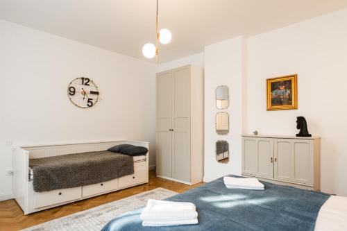 ein Schlafzimmer mit einem Bett und einer Uhr an der Wand in der Unterkunft Lara’s Loft in Braşov