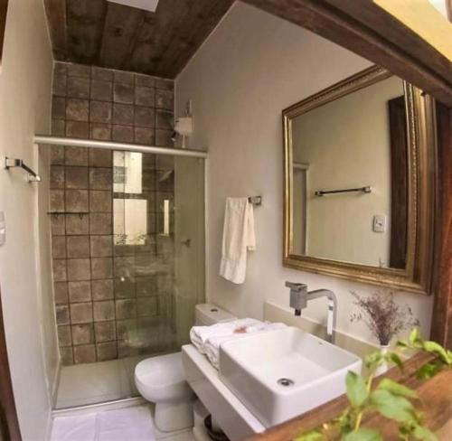 a bathroom with a sink and a shower with a mirror at Pé na Areia - Pousada in Barra Grande