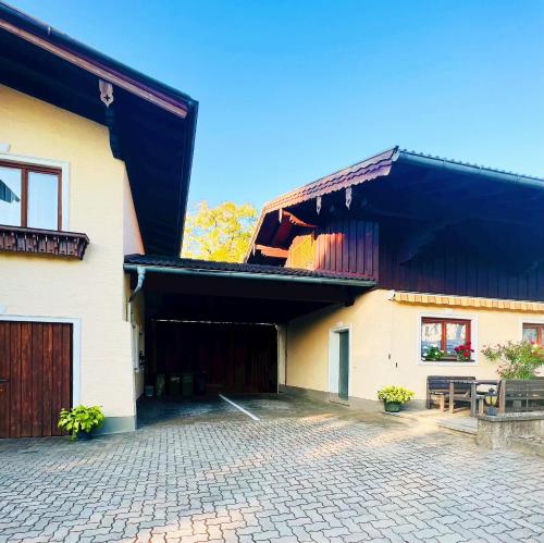 a white building with a black roof and a patio at Ferienwohnung Wallmerhof am ländlichen Wimberg in Adnet