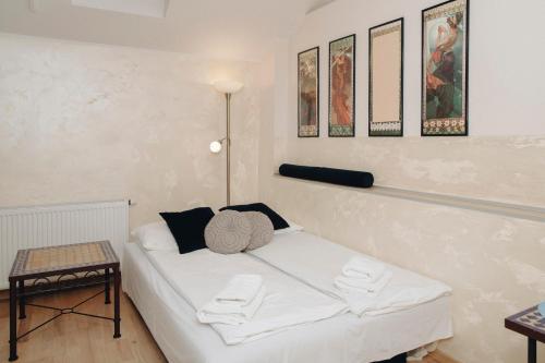 Una cama blanca en una habitación con cuadros en la pared. en Main Square Platan Loft Collection, en Cracovia