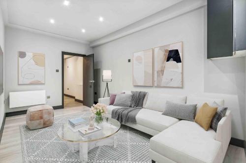 - un salon avec un canapé blanc et une table dans l'établissement Cozy London Apartment, à Londres