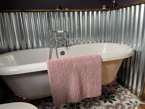 南莫爾頓的住宿－Close to Nature Hedgehogs Lodge，浴缸的侧面配有毛巾