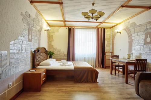 a hotel room with a bed and a dining room at Taras Bulba in Kamianets-Podilskyi