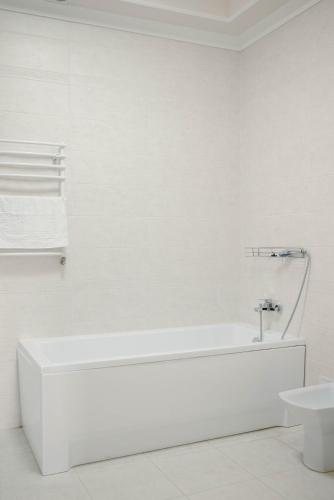 a white bathroom with a tub and a sink at Taras Bulba in Kamianets-Podilskyi