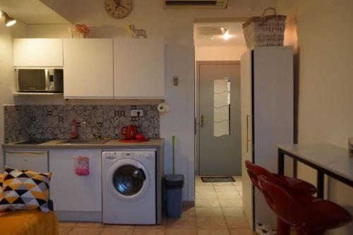 a kitchen with a washing machine in a kitchen at Magnifique studio centre-ville in Nice