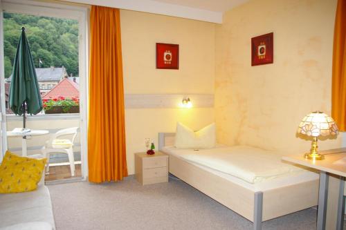 a hotel room with a bed and a balcony at Hotel Heissinger in Bad Berneck im Fichtelgebirge