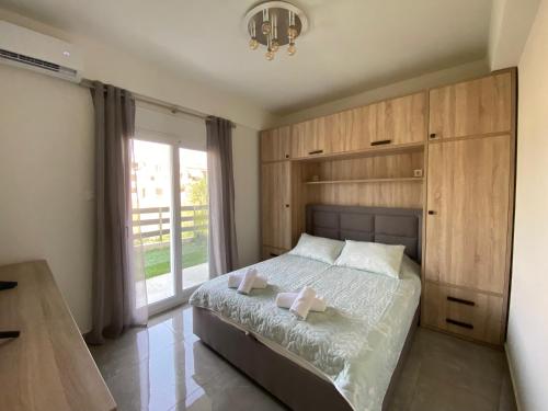 - une chambre avec un lit doté d'armoires en bois et d'une fenêtre dans l'établissement Nikiti Sunrise, à Nikiti
