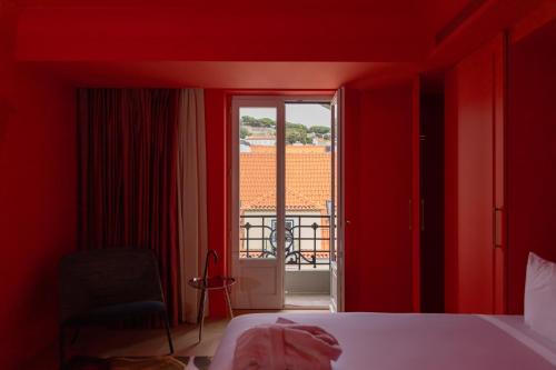 a red room with a bed and a window at Art Legacy Hotel Baixa-Chiado in Lisbon