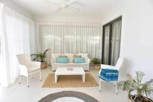 a living room with a couch and two chairs at Cap Ouest Beachfront Luxury Penthouse & Apartment in Flic-en-Flac