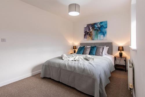 a bedroom with a bed and a painting on the wall at Holmhill House -Stunning 4-Bedroom Detached House with Ample Driveway for 1-2 Cars in Peterlee