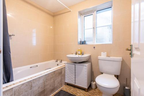 a bathroom with a toilet and a sink and a tub at Holmhill House -Stunning 4-Bedroom Detached House with Ample Driveway for 1-2 Cars in Peterlee