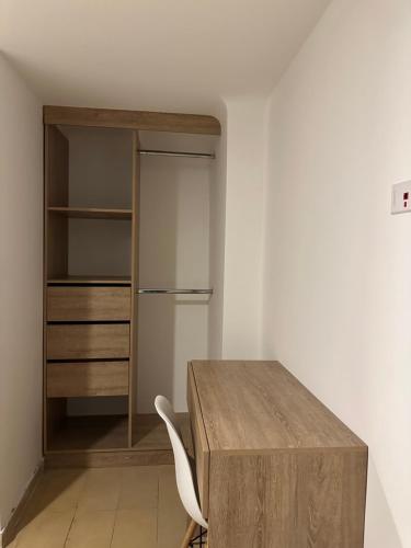 a room with a wooden table and a refrigerator at One Fourteen Rooms in Bogotá