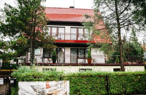 una casa con un balcón rojo en el lateral de ella en Hostel Wielka Krokiew en Zakopane