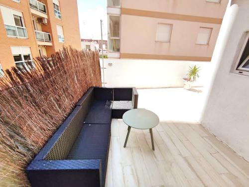 a patio with a bench and a table and a chair at Cala Nova Studios, Vinaròs in Vinarós