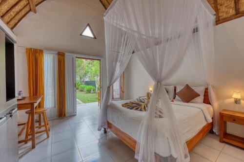 a bedroom with a bed with mosquito net at Ananta Bungalow in Nusa Penida