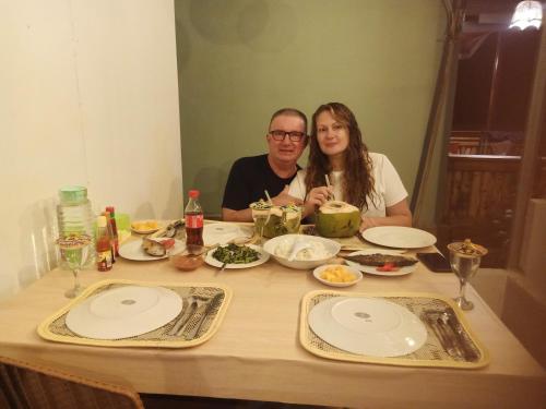 un uomo e una donna seduti a un tavolo con del cibo di Renata Cottages a Ohoililir