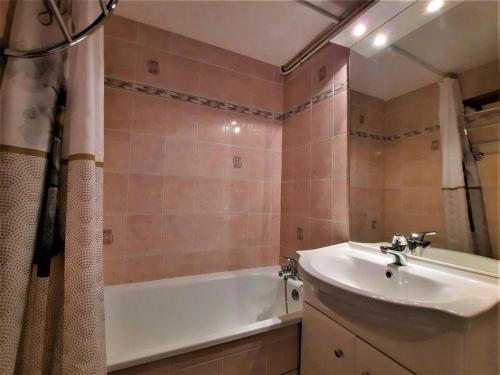 een badkamer met een wit bad en een wastafel bij Appartement Les Menuires, 2 pièces, 6 personnes - FR-1-452-205 in Les Menuires