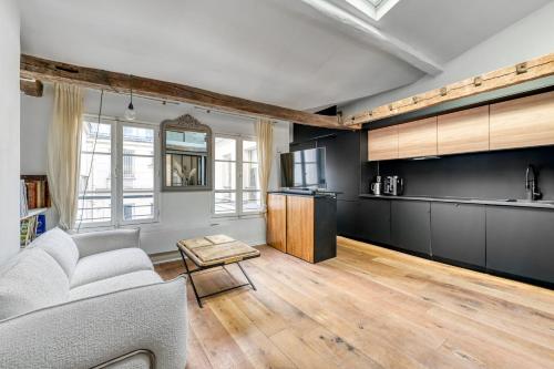 un salon avec un canapé et une cuisine dans l'établissement Luxurious flat - Square du Temple in Paris, à Paris