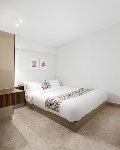 a bedroom with a large bed with white sheets at Livingville Nine in Cairo
