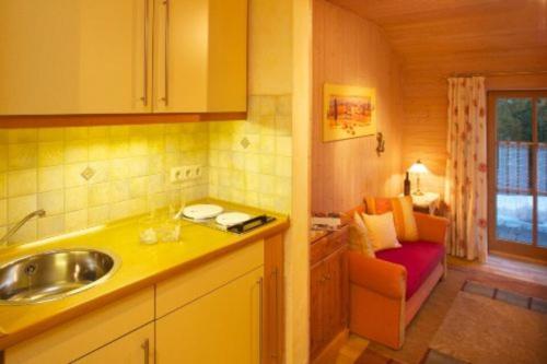 una cocina con fregadero y un sofá en una habitación en Haus Miller, en Nesselwang