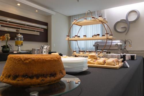 a counter with a table with plates of food on it at Green Place Ibirapuera in São Paulo