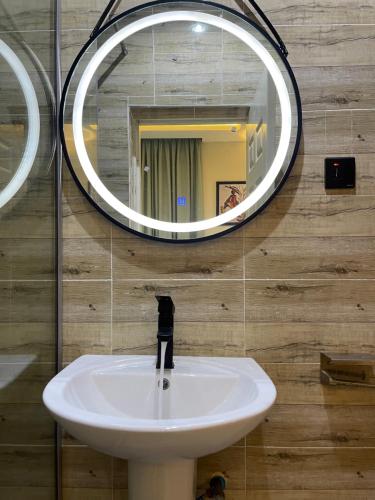 y baño con lavabo y espejo. en Luxurious Three-Bedroom Apartment In Wuye Abuja - New Base Apartments, en Dakibiu