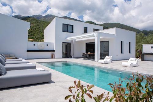 eine Villa mit einem Pool und einem Haus in der Unterkunft Eros - Afroditi Villas Collection in Nydri
