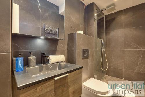 une salle de bain avec un lavabo et des toilettes dans l'établissement Urban Flat 70 - Authentic 3BDR Parisian Flat, à Paris